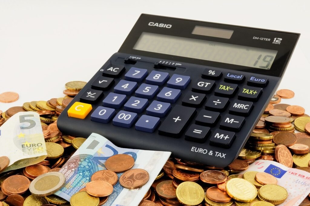 a calculator and money on a pile of coins